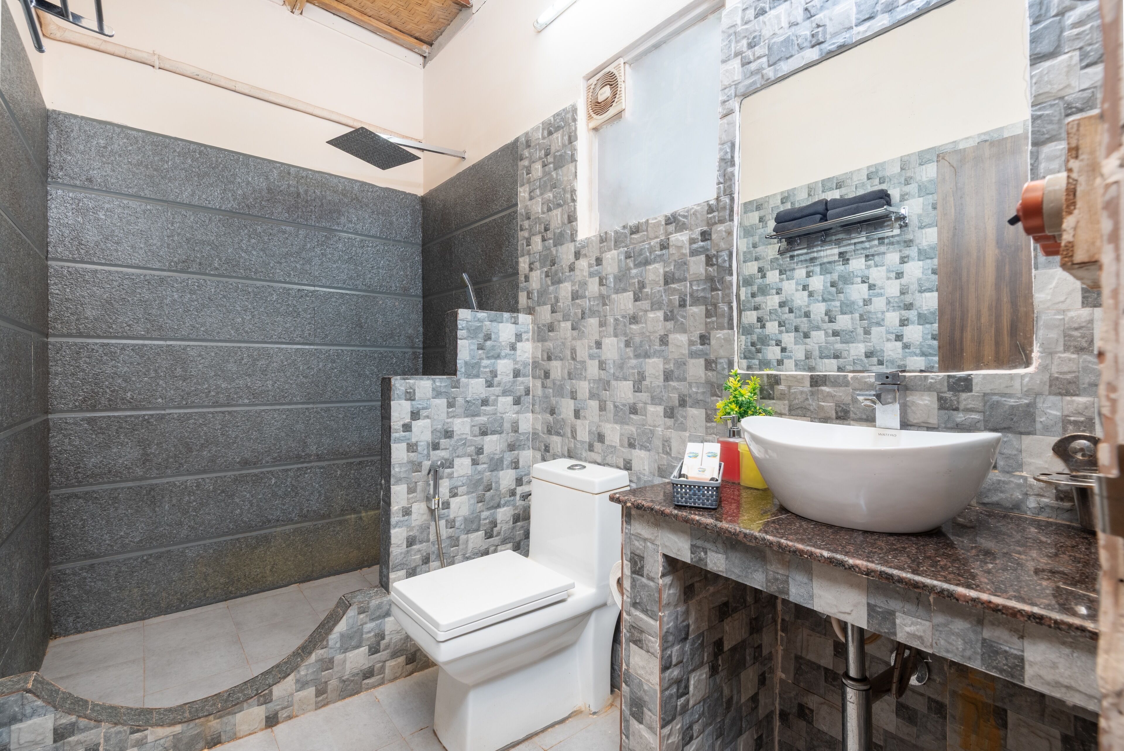 Un baño con inodoro, lavabo y zona de ducha.