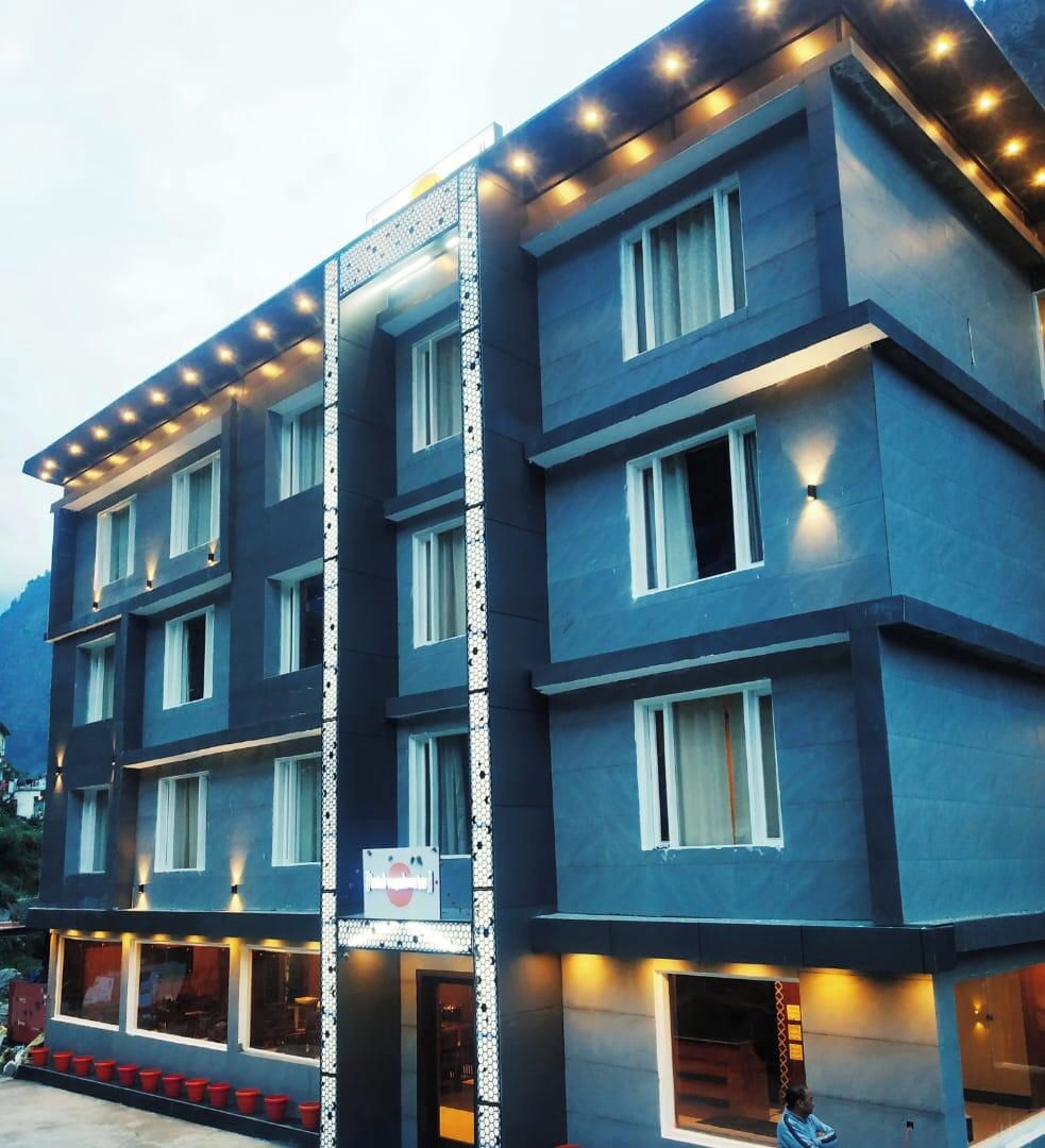 A multi-story hotel with a modern design, featuring a prominent vertical light strip and a series of windows on each floor.