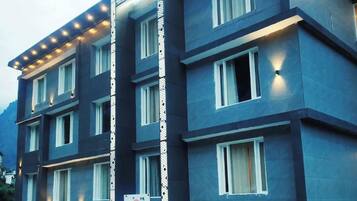 A multi-story hotel with a modern design, featuring a prominent vertical light strip and a series of windows on each floor.