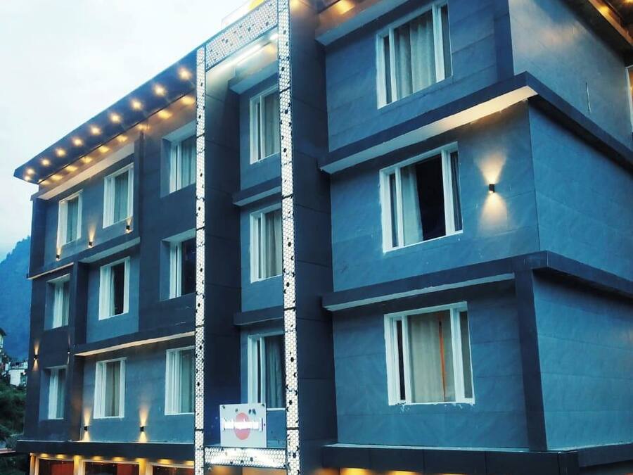 A multi-story hotel with a modern design, featuring a prominent vertical light strip and a series of windows on each floor.