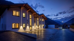 Een modern gebouw met meerdere verlichte ramen en een goed verlichte ingang.