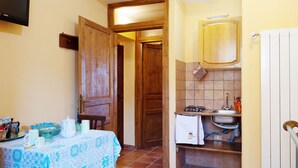 A compact kitchen with a sink, stove, and wooden cabinets. - Sun-kissed holiday home with swimming pool (Itieli)