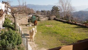 A rural landscape with a stone wall, a fenced area, and a mountain range in the background. - Sun-kissed holiday home with swimming pool (Itieli)