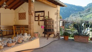 A rustic building with a wooden bench, potted plants, and a brick wall. - Sun-kissed holiday home with swimming pool (Itieli)