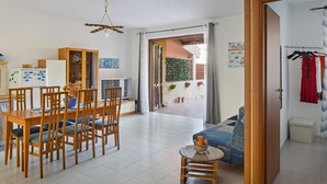 Un amplio espacio de sala con una mesa de comedor, sillas, un sofá y una pequeña mesa de centro.