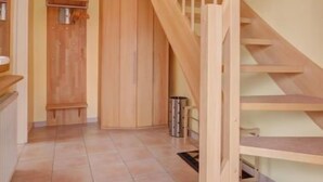A wooden staircase with a handrail, a ceiling fan, and a tiled floor. - Katamaran II by Interhome (Burhave)
