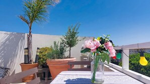 A terrace with a table, potted plants, and a clear blue sky. - Le Nadir by Interhome (Fréjus)