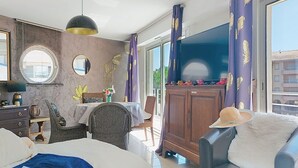 A hotel room with a bed, a desk, a chair, a wardrobe, and a view of the outside. - Le Nadir by Interhome (Fréjus)