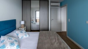 A bedroom with a bed, a bedside lamp, a wardrobe, and a door. - La Spelunca by Interhome (Cargèse)