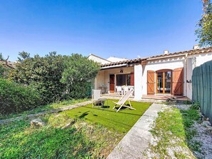 A house with a patio, a small garden, and a wooden fence.