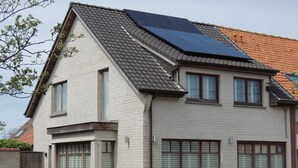 Ein zweistöckiges Haus mit Satteldach, Solaranlage und Fensterläden.