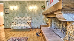 A living room with a sofa, fireplace, and bookshelves.
