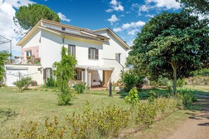 Une maison à deux étages dotée d’un balcon, d’un porche abrité et d’un jardin bien entretenu.