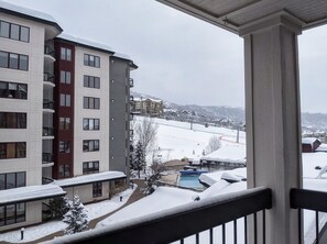 A multi-story hotel with balconies, a pool, and a snowy landscape in the background. - Ski-in/Out, Walk to Base Area - Torian Plum - Pool& Hot Tubs (Steamboat Springs)