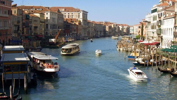A canal with boats and gondolas, lined with historic buildings. - Belvilla by OYO Appartamento N1 (Venice)