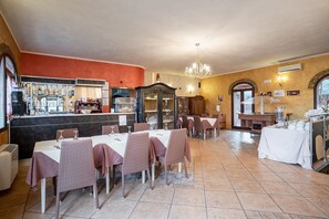 Ein Restaurant mit gedeckten Tischen, einer Bar und einer Theke mit verschiedenen Artikeln.