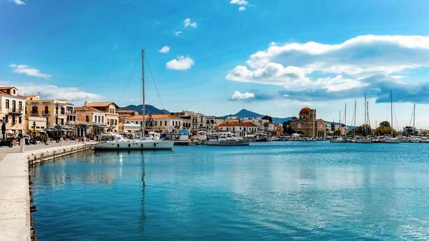 A waterfront marina with boats docked, buildings along the shore, and a clear blue sky. - Holiday Home in Aegina Island (Aegina Island)