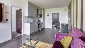 A modern apartment with a kitchen, dining area, and living room.