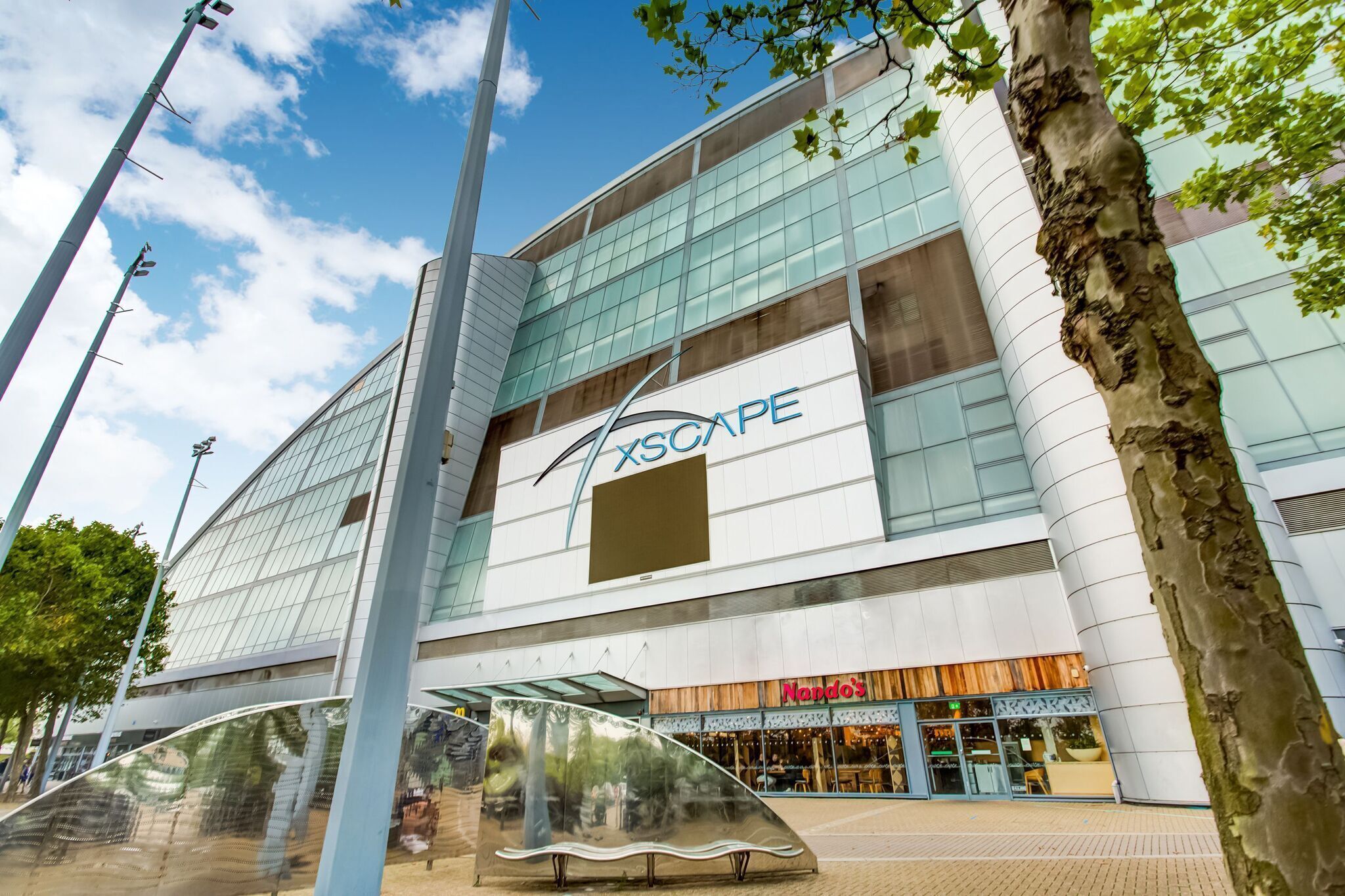 Un edificio moderno con fachada de vidrio y el logo 'Xscape'.