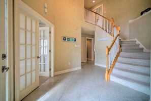 Staircase leads to a hallway with doors and a large glass door.