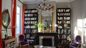 Una biblioteca acogedora con estanterías, una chimenea y una araña.