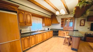 Una cocina con gabinetes de madera, una isla central, un microondas y un fregadero.