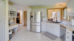 A modern kitchen with white cabinetry, stainless steel appliances, and a built-in oven.