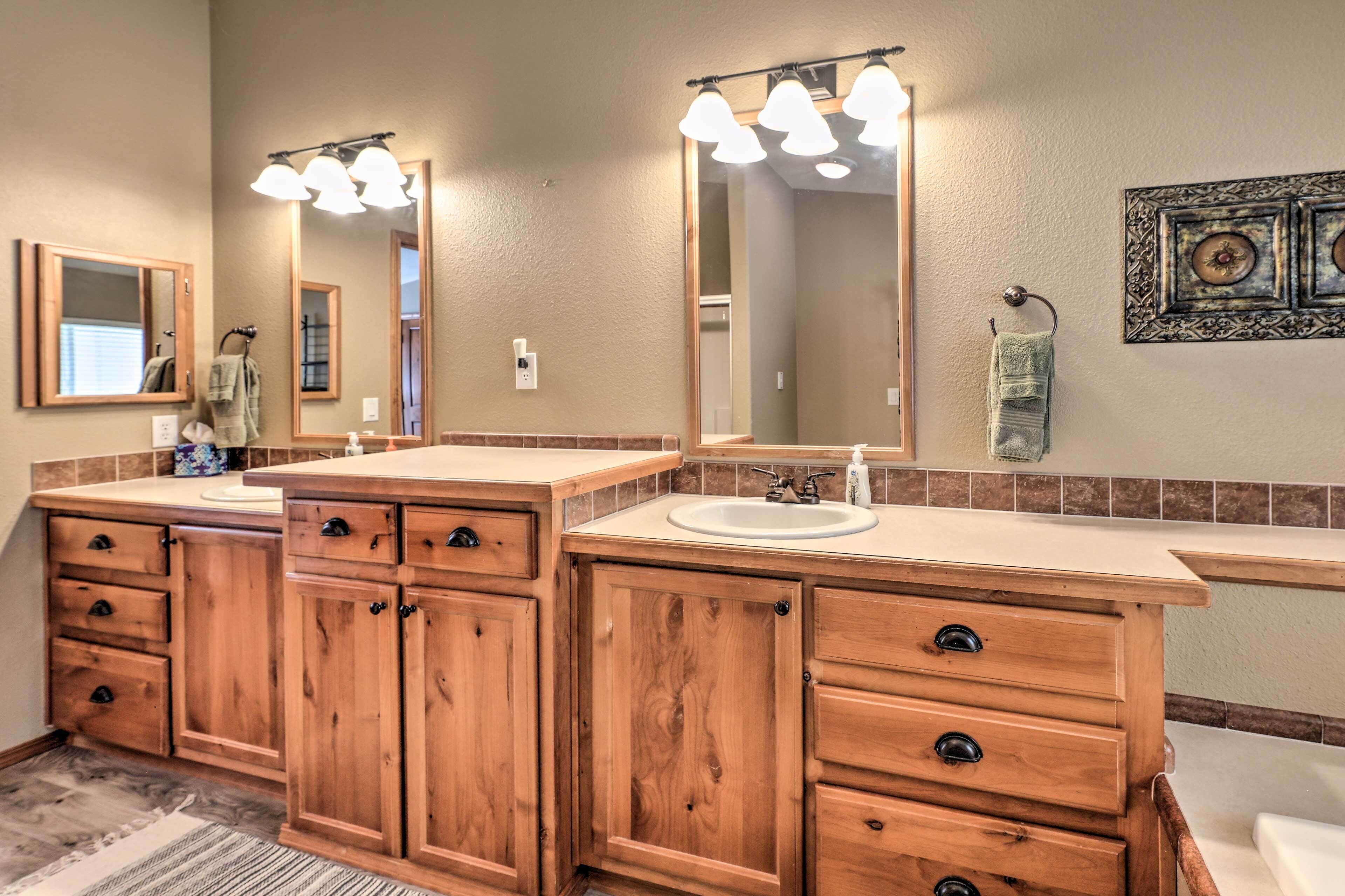 A bathroom with wooden cabinets, a sink, and a large mirror.