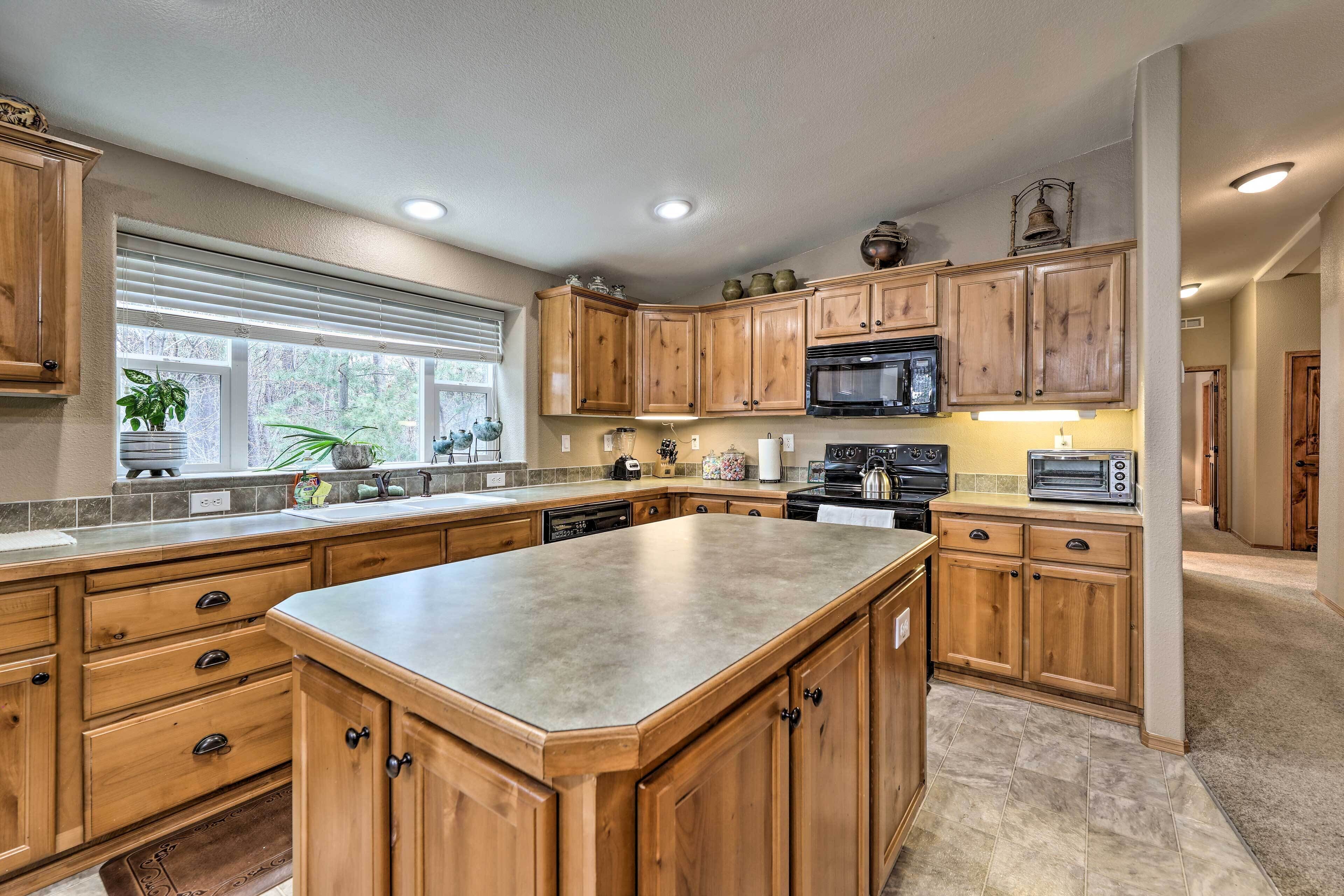 A spacious kitchen with wooden cabinets, a large island, and a built-in microwave.