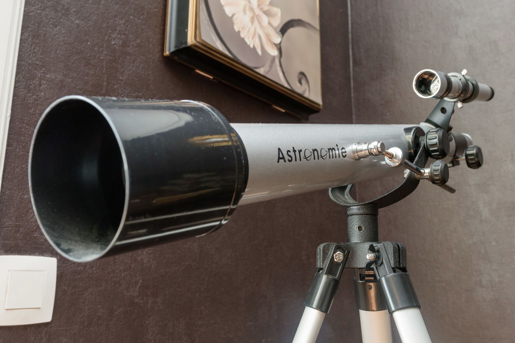 Un télescope de la marque « Astronomie » fixé sur un trépied.