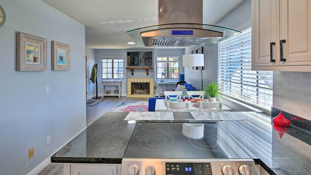 A modern kitchen with a central island, built-in appliances, and a fireplace. - Breezy Monterey Apt: Walk to Downtown & Beach (Monterey)