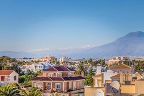 A residential area with houses, some with satellite dishes, and a mountain in the background. - Apartment in Roquetas near Sea Beach (Roquetas de Mar)