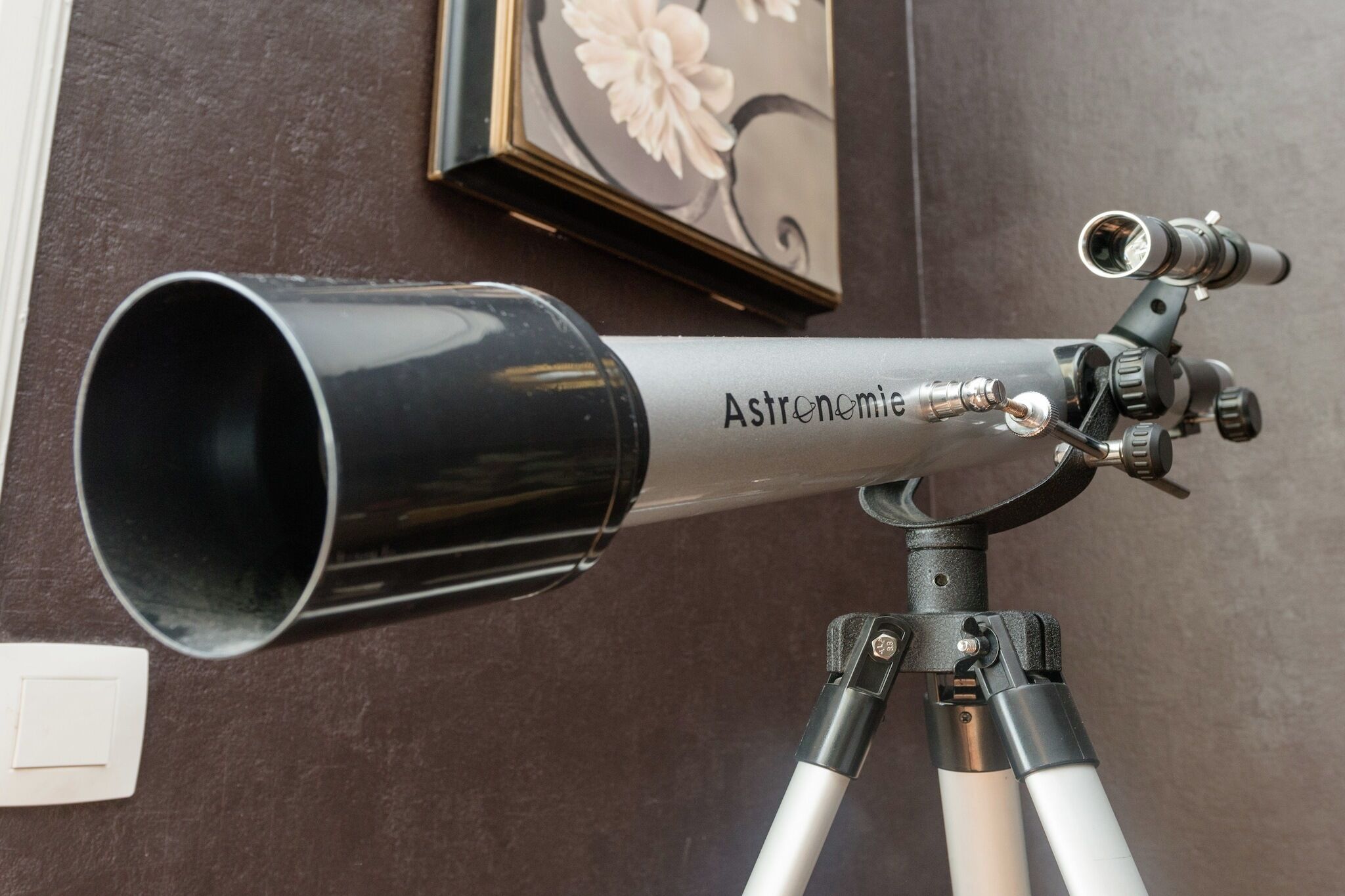 A telescope on a tripod with the brand name "Astronomia" visible on its body.