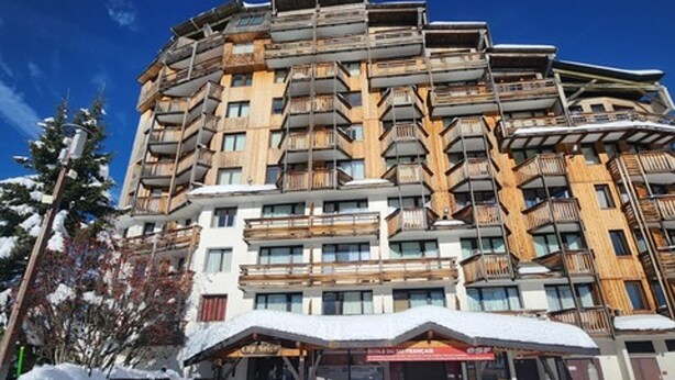 Ein mehrstöckiges Hotel mit Balkonen und einem Schild für einen Skiort.