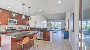 A modern kitchen with granite countertops, stainless steel appliances, and pendant lighting. - Mtn & Golf Course Views: Relaxing Palm Desert Gem (Palm Desert)