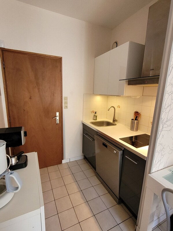 A compact kitchen with a dishwasher, a sink, and a stove. - Duplex apartment in the heart of La Roche Bernard (La Roche-Bernard)