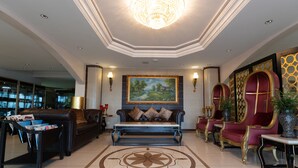 A spacious lobby with a large sofa, a coffee table, and a decorative rug. - L'Etoile d'Or Hotel London (Libreville)