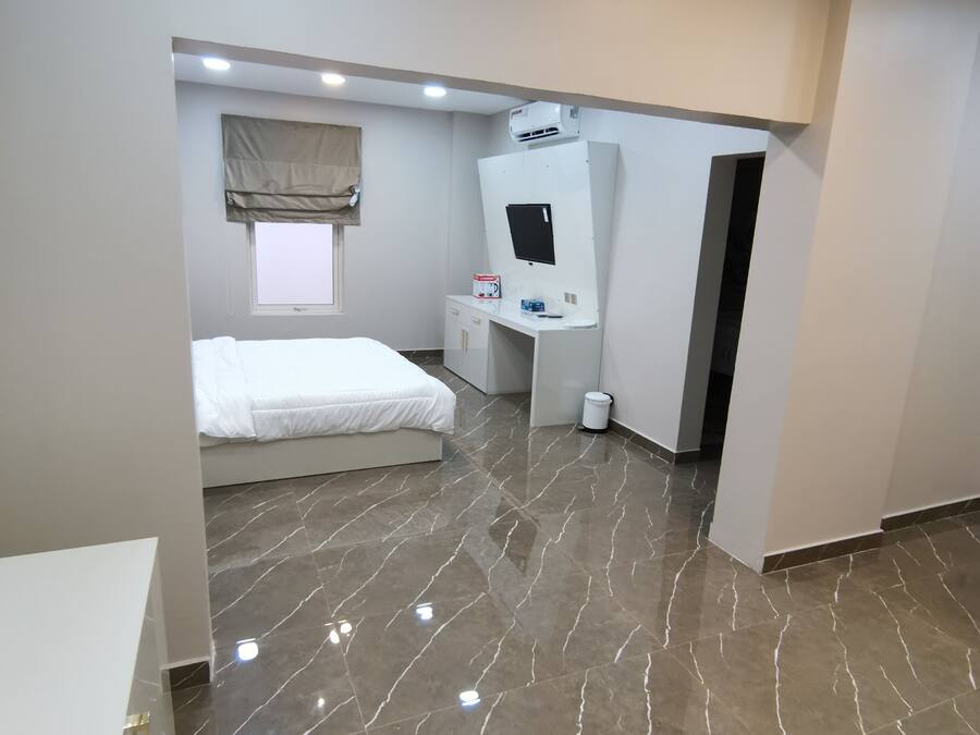 Una habitación de hotel moderna con cama, escritorio y televisión.