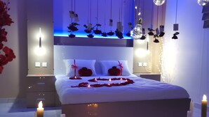 A modern bedroom with a bed, bedside tables, and a nightstand. - MARINA SOHAR HOTEL (Sohar)