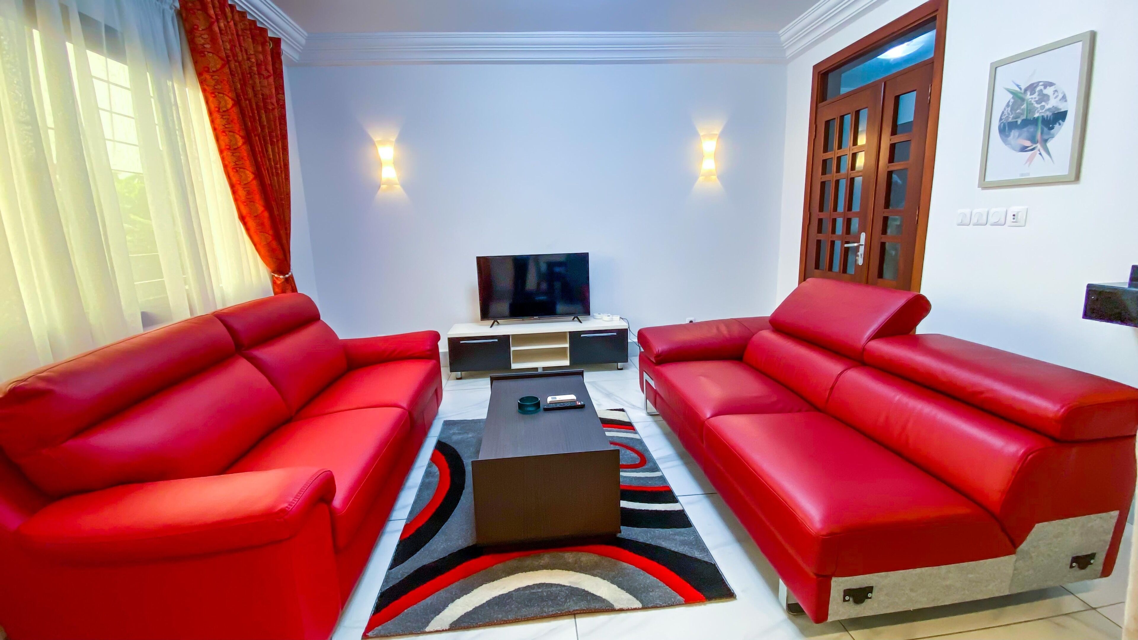 Deluxe-Apartment | Wohnbereich | 32-Zoll-Flachbildfernseher mit Satellitenempfang, Fernseher