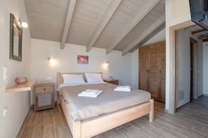 Une chambre à coucher avec un lit en bois, des tables de chevet, une commode, un miroir et une armoire.