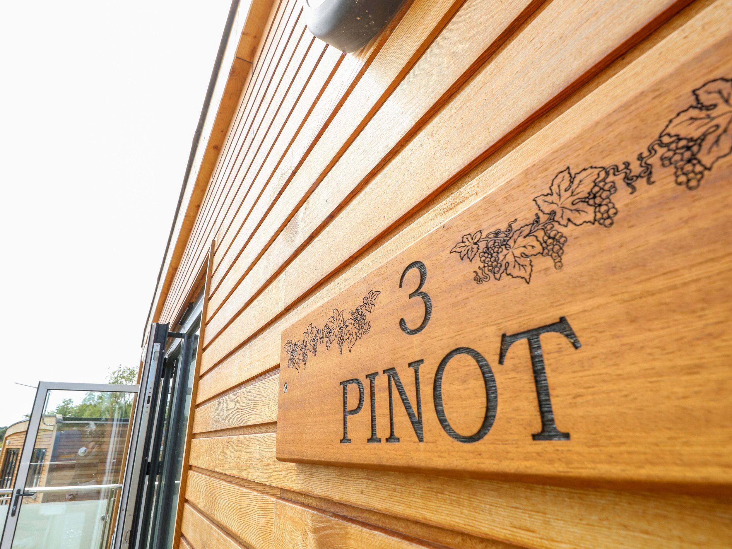 Un panneau en bois portant le chiffre 3 et le mot « PINOT ».