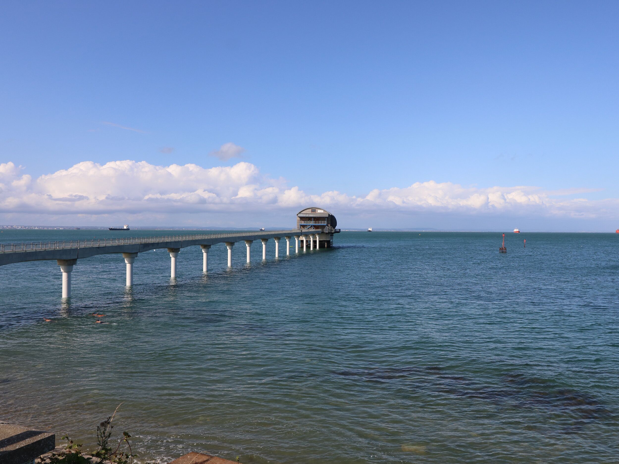 A pier extending into the water with a building at the end.