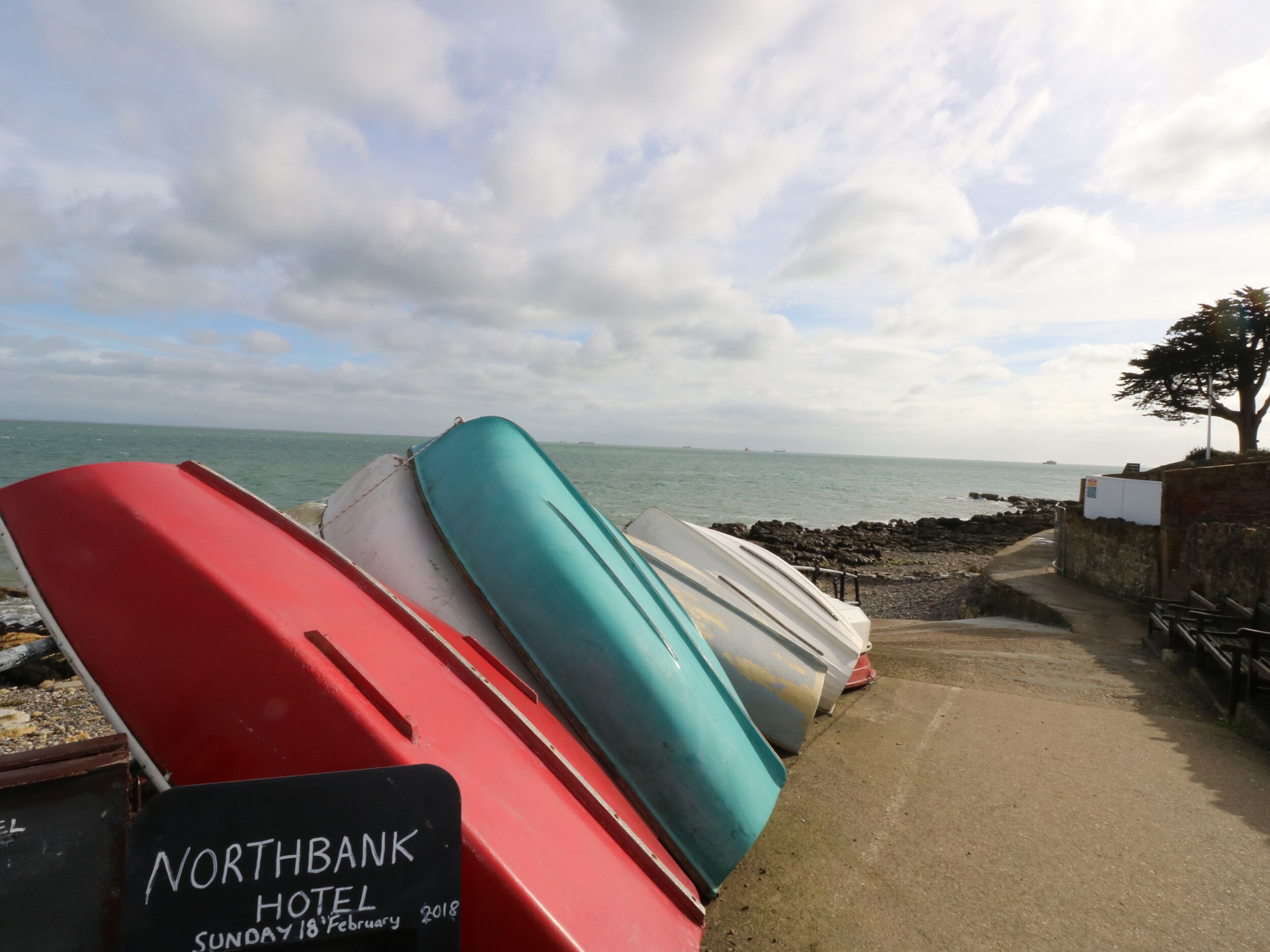 A row of boats at a dock with a sign for Northbank Hotel visible in the foreground.