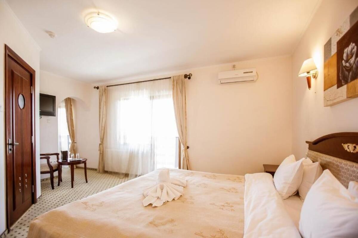 A hotel room with a bed, a desk, and a chair.
