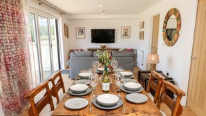 A dining area with a wooden table set for six, surrounded by wooden chairs. - Champagne (Ryde)