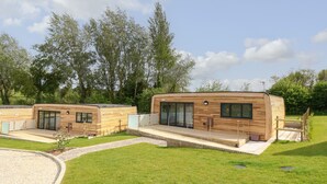 A modern, two-story wooden cabin with large windows and a covered outdoor area. - Cava (Ryde)