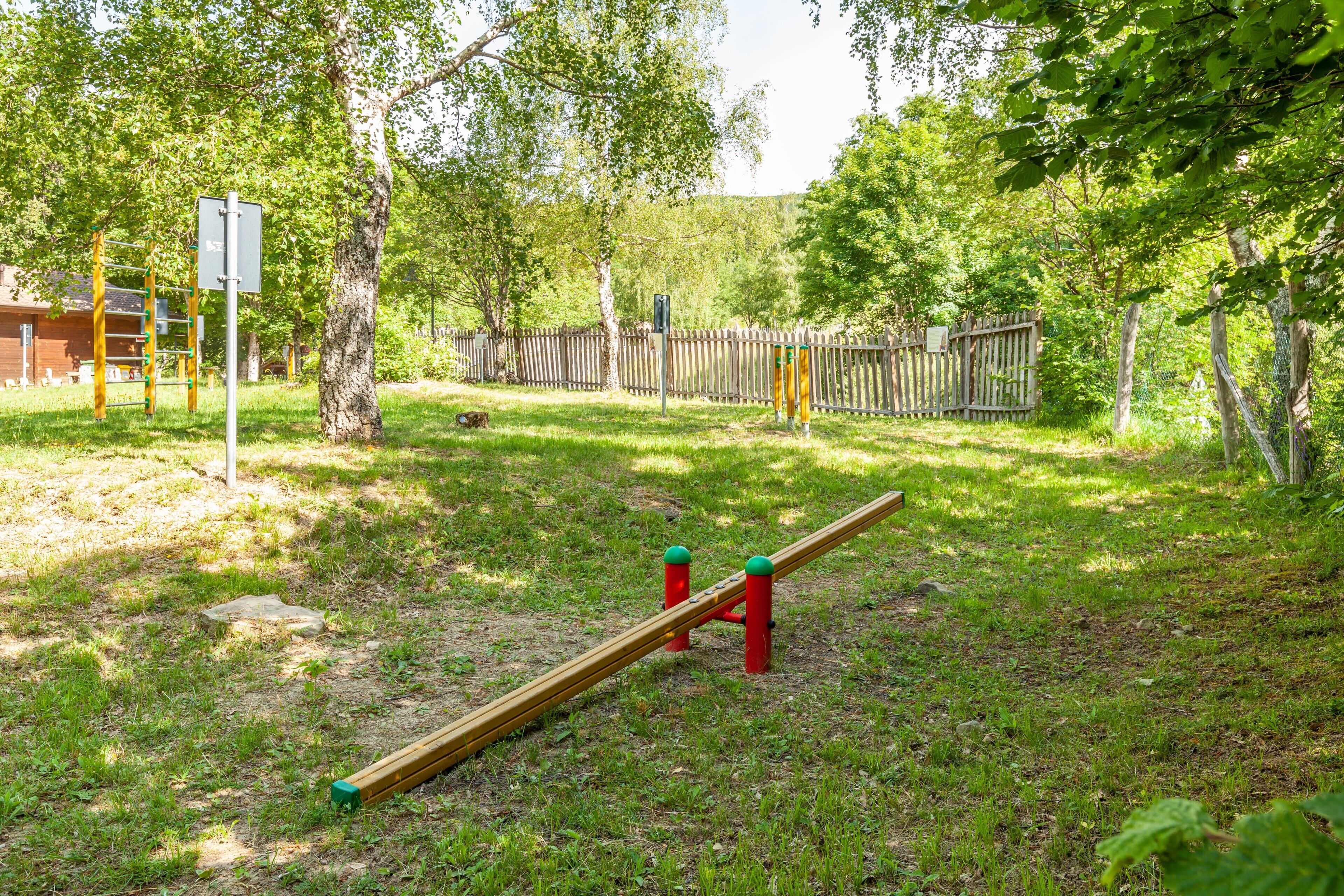 Un'area giochi con altalena, struttura per arrampicata e recinzione.