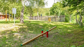 Un'area giochi con altalena, struttura per arrampicata e recinzione.