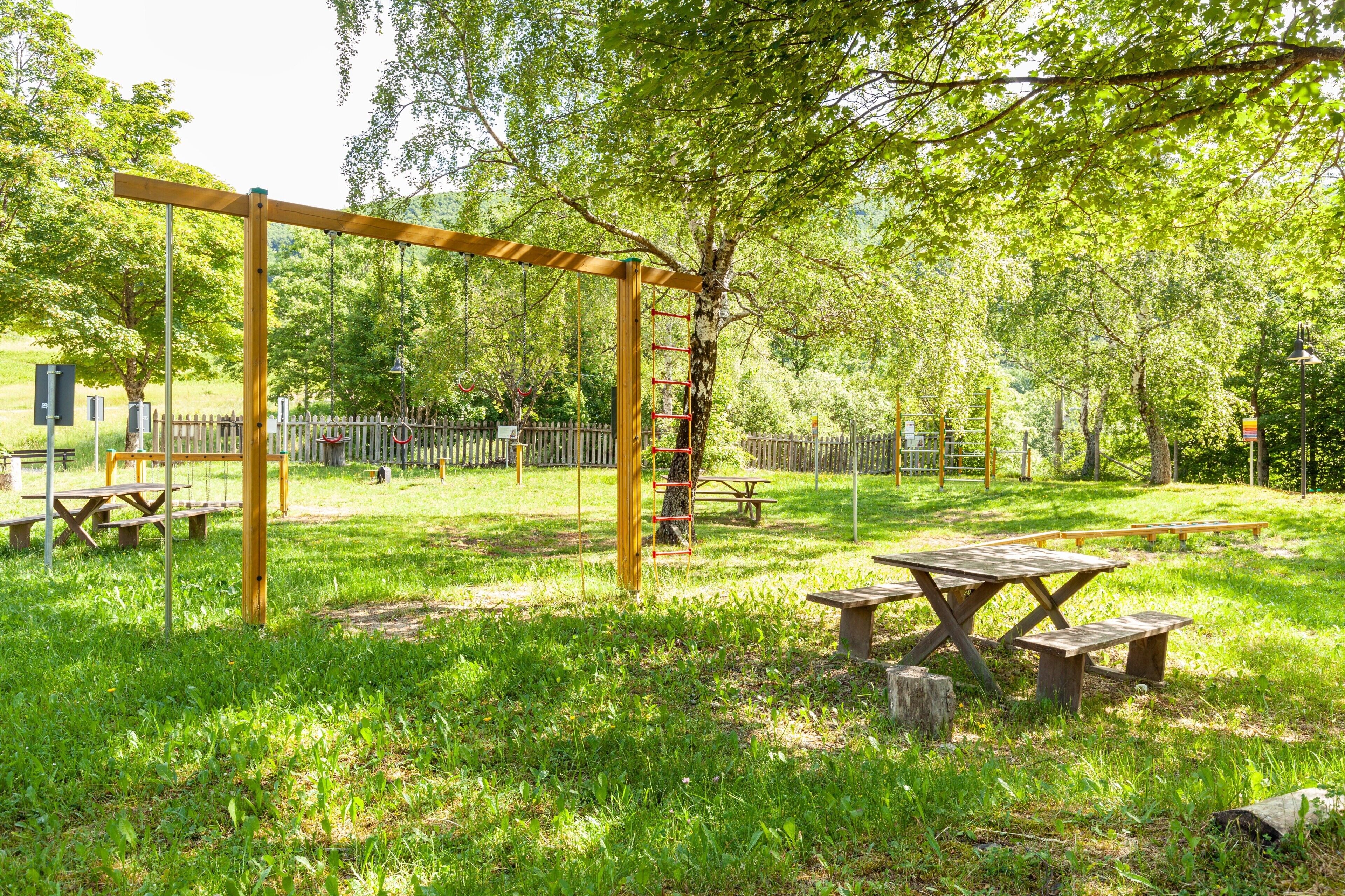 En park med picknickbord och en gunga.